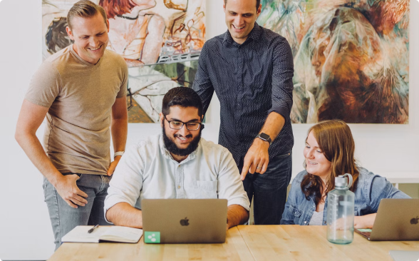 A team collaborating around a laptop